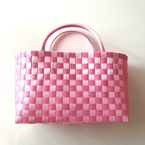 ファンシーなピンク色のかごバッグ