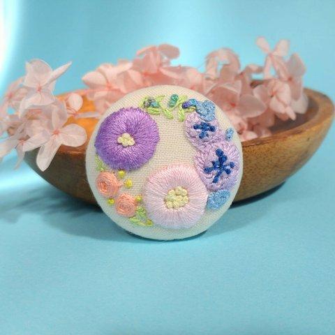 【リース刺繍　くるみボタン　ブローチ】紫とピンクの丸いお花とカラフル小花のリース