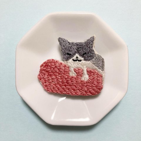 クッションをこねる猫の刺繍ブローチ