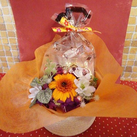 花柄の陶器にアレンジしたオレンジのガーベラのプリザーブドフラワーと海の生き物などの形ね焼き菓子５袋のギフトセット