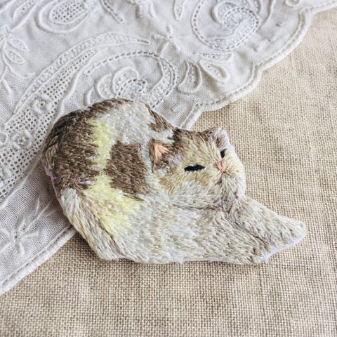 「ん゛〜っ」と伸びをする猫の刺繍ブローチ