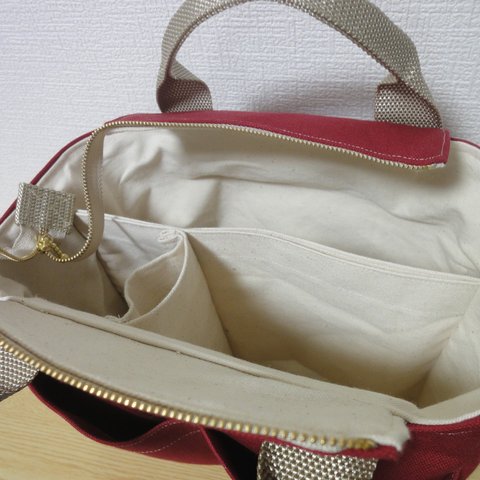 ワインレッドの帆布生地を使った仕切りタイプのトートバッグ。整理しやすく容量がたっぷりのバックです。